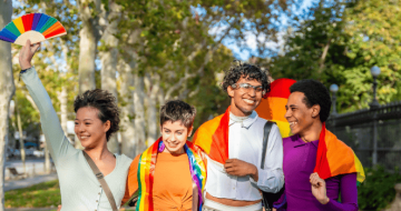 Group of travellers with rainbow flags, exercising LGBTQIA+ travel safety.