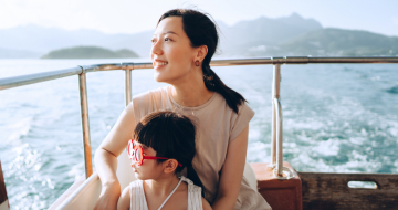 Mum and young daughter on a cruise ship, admiring the view 