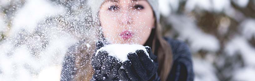 female with snow in hands